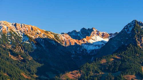 Low angle view of mountains against clear blue sky