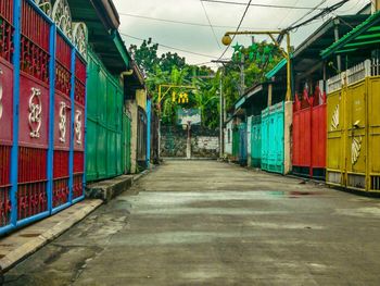 Empty footpath amidst buildings in city