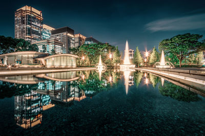 Illuminated building in city against sky at night