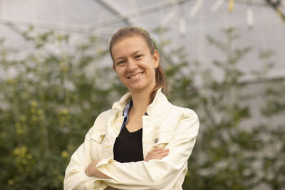 Young woman standing as vegetable grower or farmer in a greenhouse