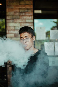 Portrait of young man smoking outdoors