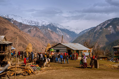Group of people on mountain range against sky