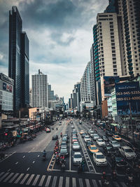 Traffic on city street amidst buildings against sky