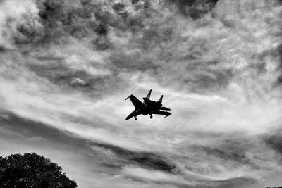 Low angle view of silhouette airplane against sky