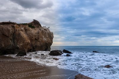 Rocks on beach against sky