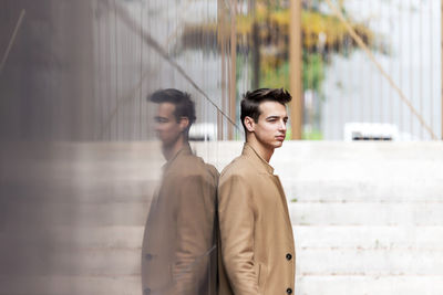 Young man standing against wall