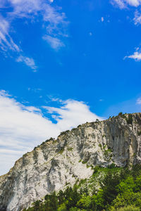 Low angle view of mountain against blue sky