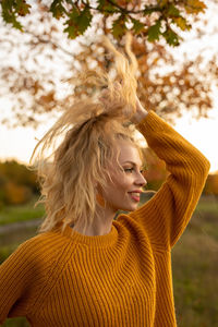 Portrait of young woman looking at tree