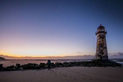 Lighthouse at seaside during sunset