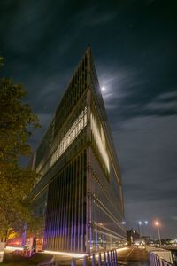 Low angle view of illuminated buildings against sky at night