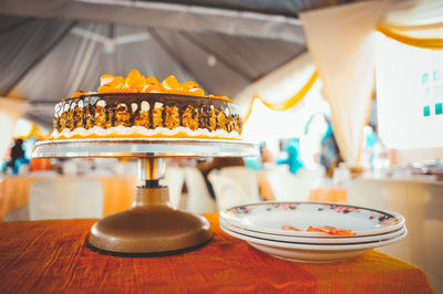 Close-up of cake by plates on table during party