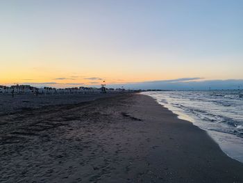 Scenic view of beach against clear sky during sunset