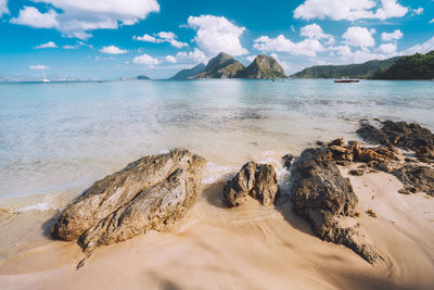 Scenic view of rocks on beach against sky