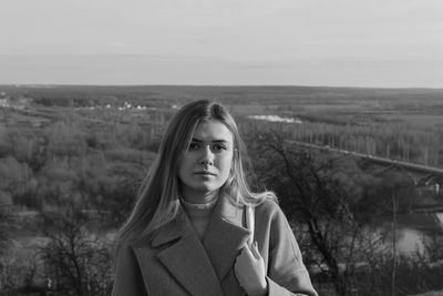 Portrait of beautiful woman standing against sky