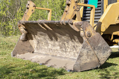 Clearing and leveling a private land plot. yellow excavator driving earth in a wide bucket