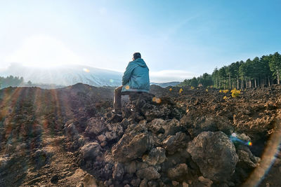 Mature man enjoying freedom, while admiring panoramic view of snowy summits of active volcano etna.