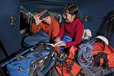 Couple looking at guide book in the back of their camper van