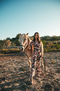 The girl relaxes with the white horse in the nature park