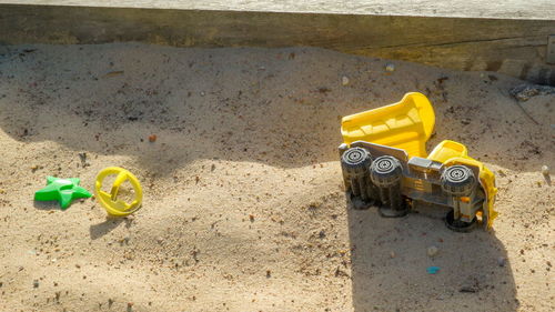 High angle view of yellow toy on sand