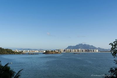 Calm sea against clear blue sky