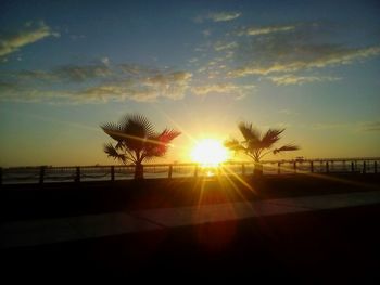 Silhouette beach against sky during sunset