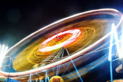 Low angle view of light trails against sky at night