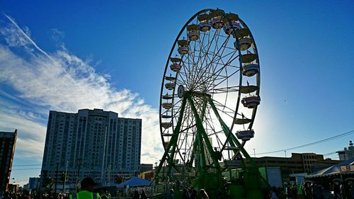 Low angle view of ferris wheel against blue sky