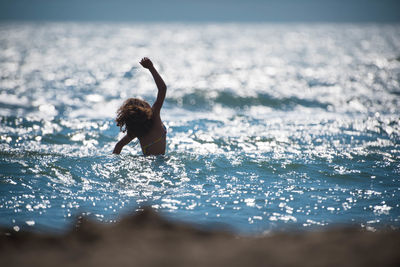 Woman in sea against sky