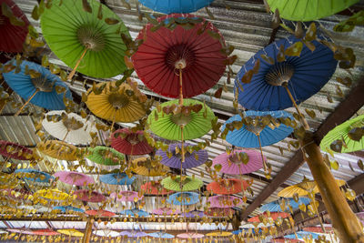 Low angle view of multi colored umbrellas hanging at market stall