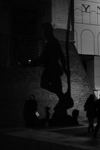Shadow of people walking on street at night