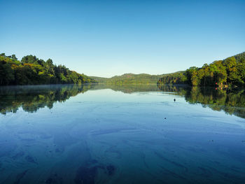 Scenic view of lake against clear blue sky