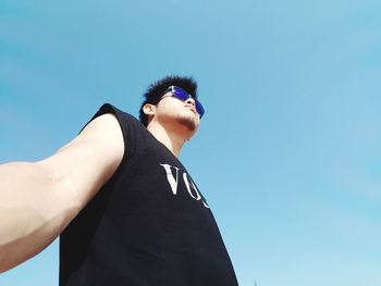 Low angle view of man against clear blue sky