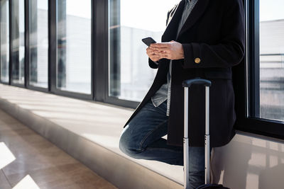 Man using mobile phone at window