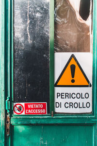 Close-up of warning sign on wooden door