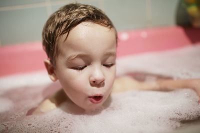 Close-up of shirtless boy in bathtub