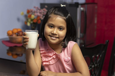 Portrait of smiling girl sitting at home