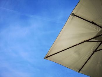 Low angle view of parasol against blue sky