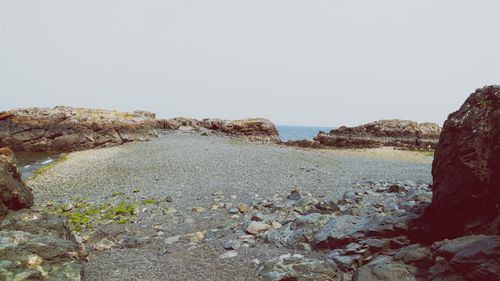 Rocks on beach against clear sky