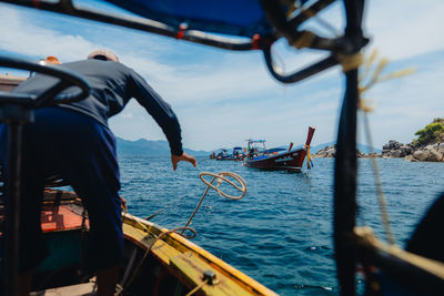 Rear view of man sitting on boat