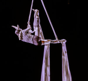 Low angle view of woman performing over black background