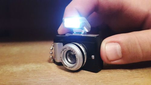 Cropped image of hand holding camera