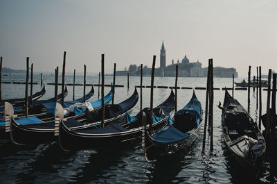 Boats moored in sea against clear sky