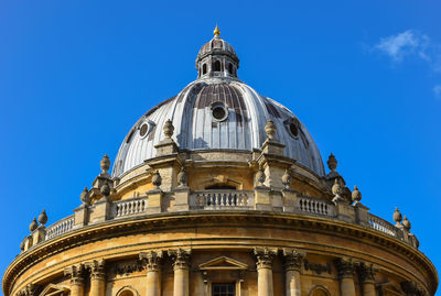 Low angle view of oxford university against blue sky