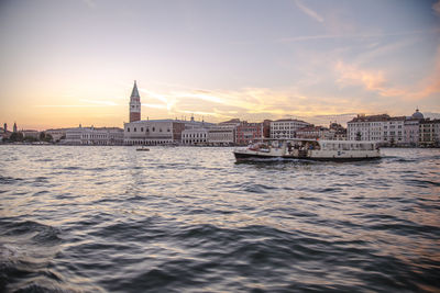 Scenic view of sea against buildings during sunset