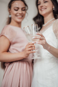 Close-up of a smiling young woman drinking glass