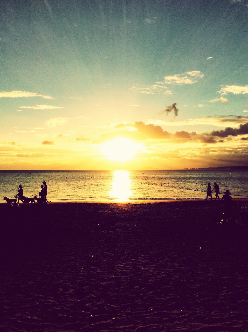 water, horizon over water, sea, sunset, tranquil scene, scenics, beach, tranquility, silhouette, sky, sun, beauty in nature, idyllic, incidental people, nature, shore, majestic, vacations, relaxation, calm, cloud, sunbeam, cloud - sky, outdoors, orange color, remote, non-urban scene, coastline