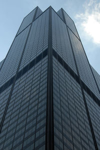 Low angle view of glass building against sky