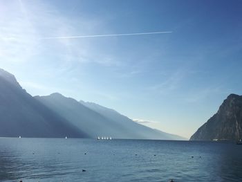 Scenic view of sea and mountains against blue sky