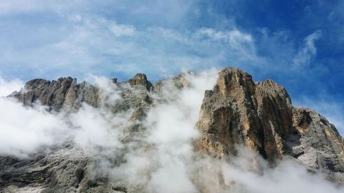 Low angle view of rocks in mountains against sky