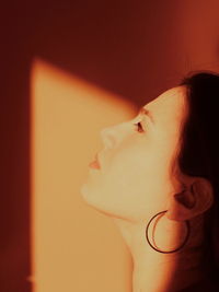 Close-up of young woman against wall at home